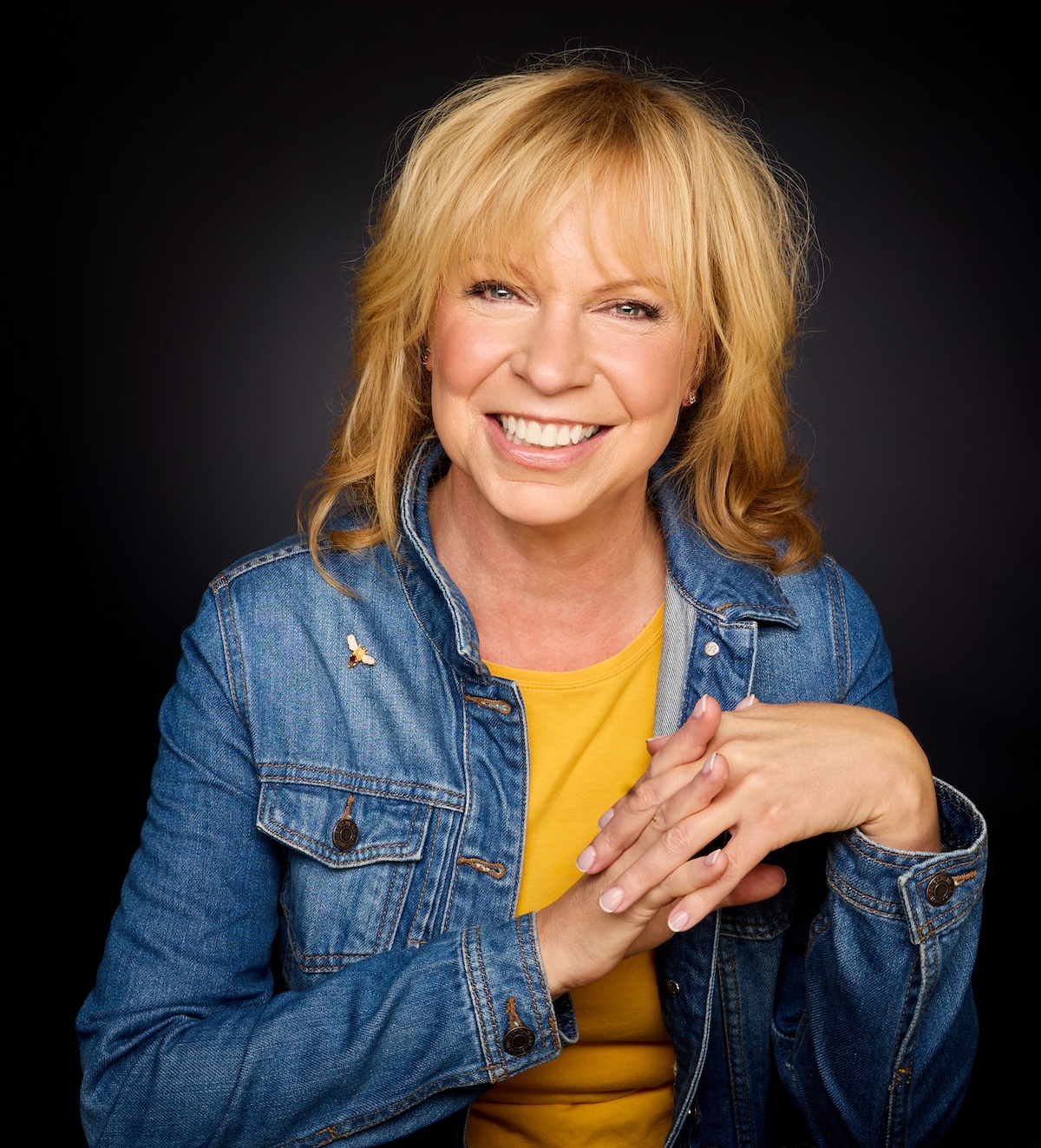 Paula Ketterer smiling against a dark background